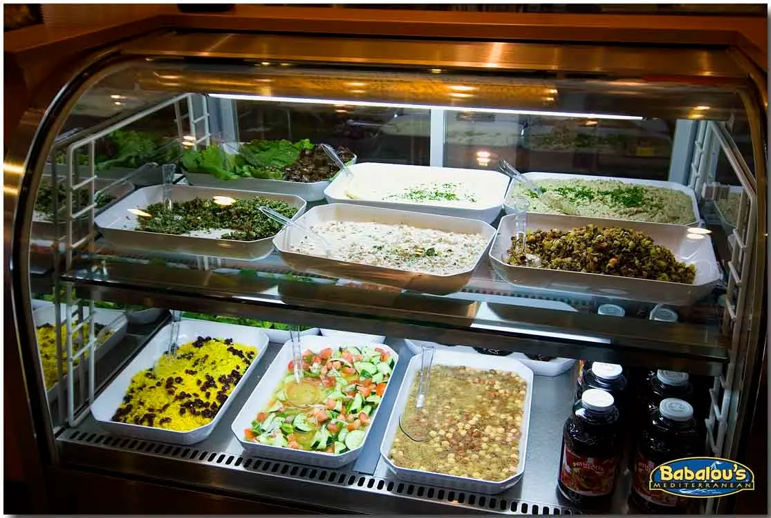 Display case with daily salads, hummus and rice
