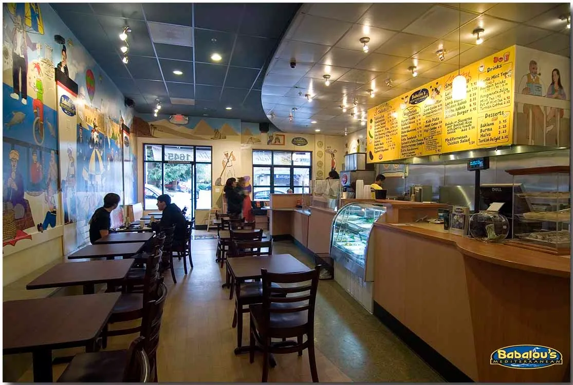 Guests dining beneath Babalou's colorful Mediterranean mural