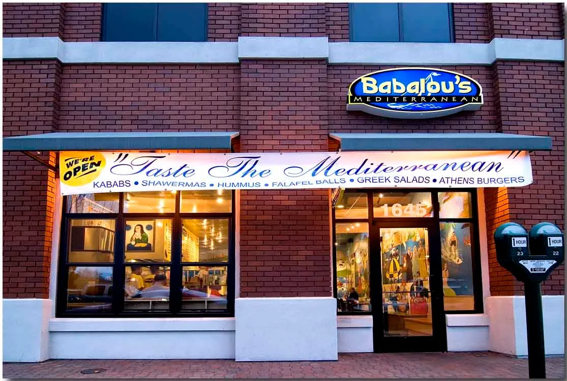 Babalou's storefront at dusk under the Taste The Mediterranean sign